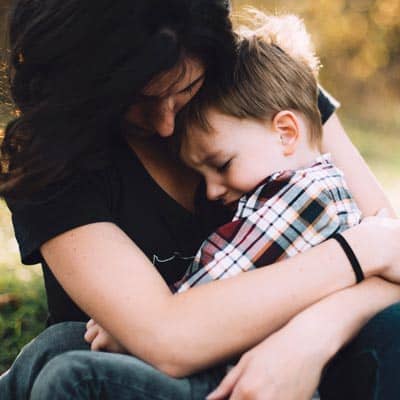 Mother and son hugging.