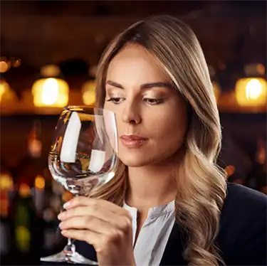 woman looking at a glass of wine and asking, Am I addicted?