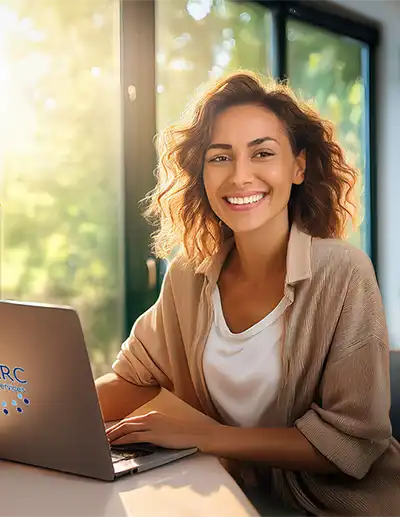Woman at a laptop smiling.