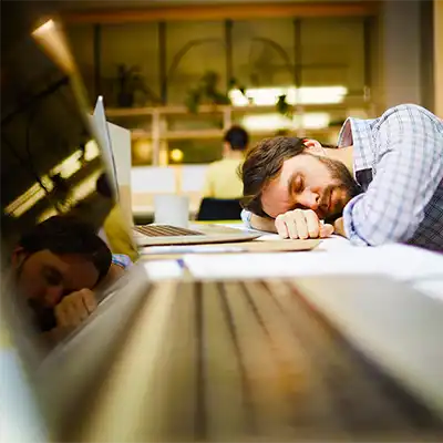 Man sleeping at his desk, hungover