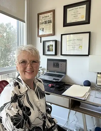 Woman at a laptop smiling.