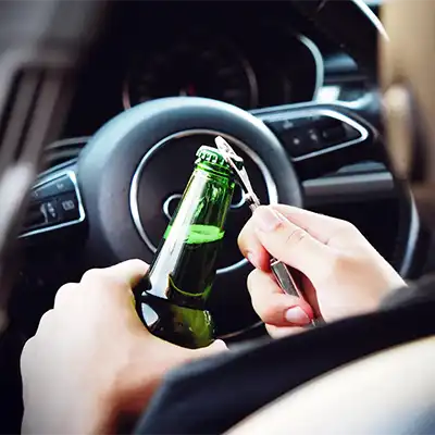 Addiction perspective, a person opening a beer in a car.
