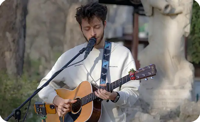 a man playing guitar and signing.
