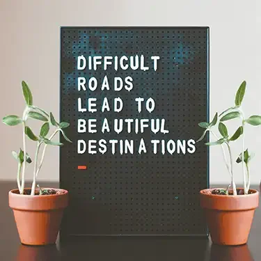 Motivational approaches sign saying; difficult roads lead to beautiful destination.